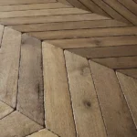 Angled view of textured chevron parquet floor.