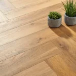 Close-up of light oak herringbone floor with plants