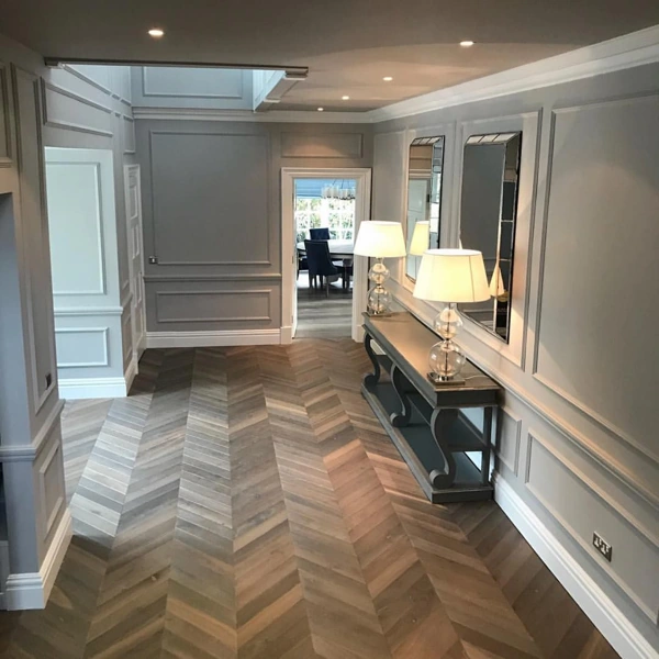 Grey wood-paneled hallway with chevron floors