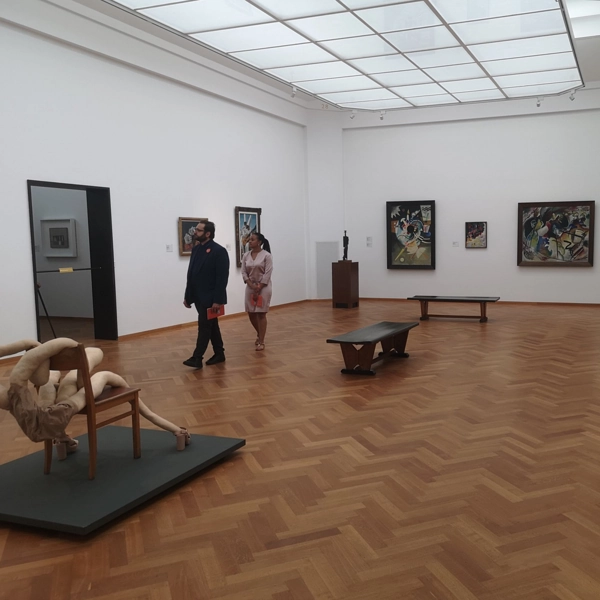 Spacious art gallery with warm wood parquet.
