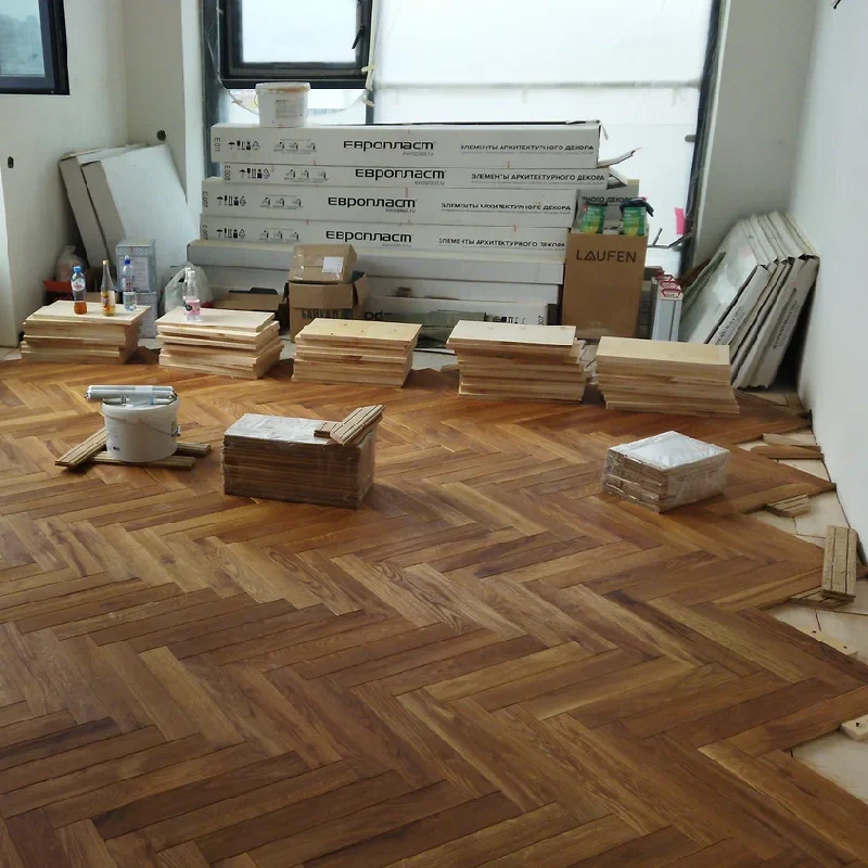 herringbone-patterned wooden parquet floor in a room under construction