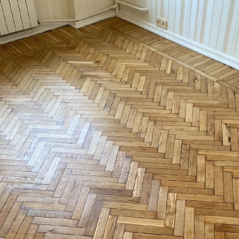 wooden parquet flooring arranged in a classic herringbone pattern.