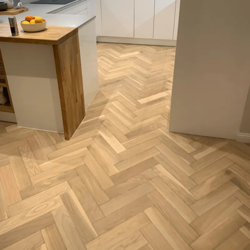 Blonde oak herringbone parquet floor with grey armchairs