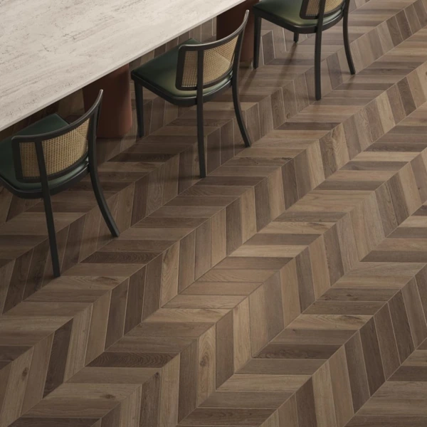 Chevron patterned wooden flooring in a modern dining room.
