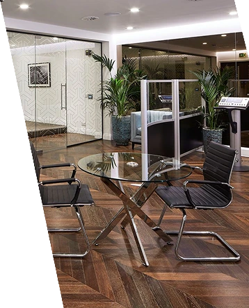 Dark chevron wood flooring in a modern office setup.
