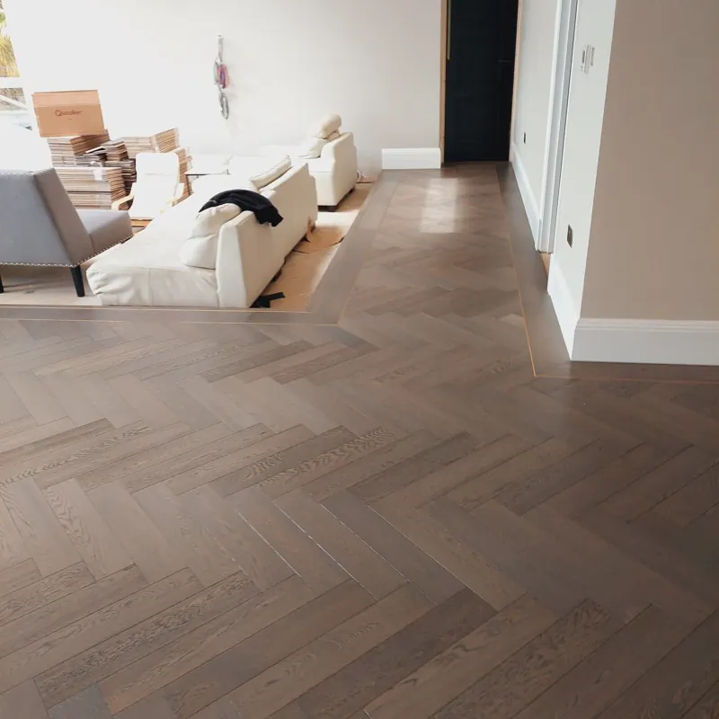 Rich dark oak herringbone wood floor in cozy living room