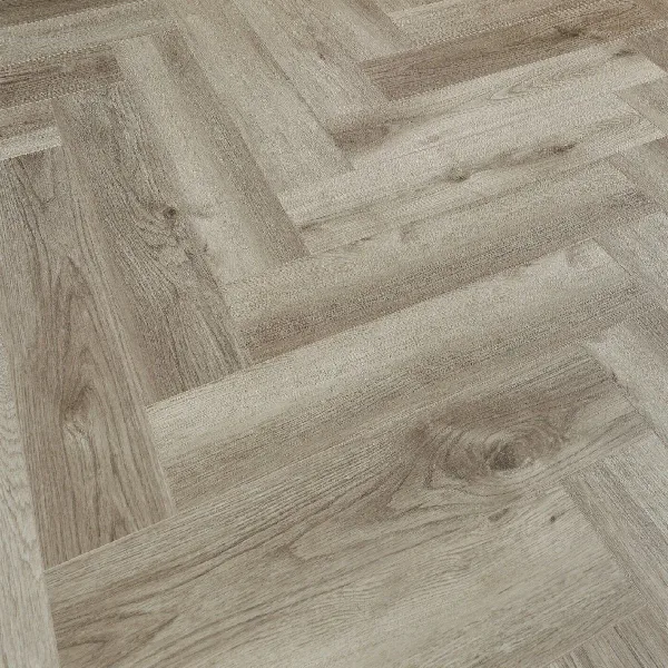 SPC flooring in a light, weathered gray-brown wood grain herringbone design