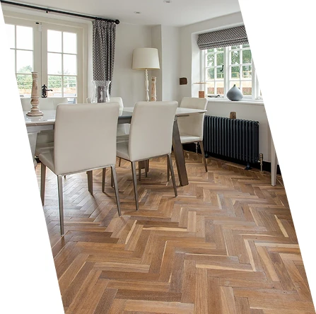Warm oak herringbone wood flooring in bright dining room