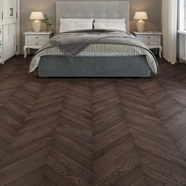 Dark brown oak chevron parquet flooring in a modern bedroom