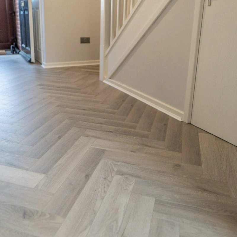 Grey wood chevron parquet flooring in a hallway