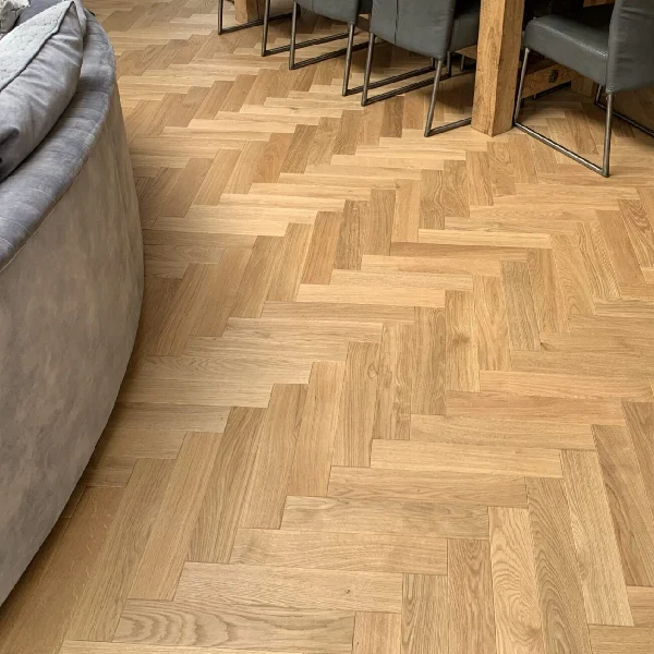 Herringbone-pattern engineered oak parquet flooring in a living room