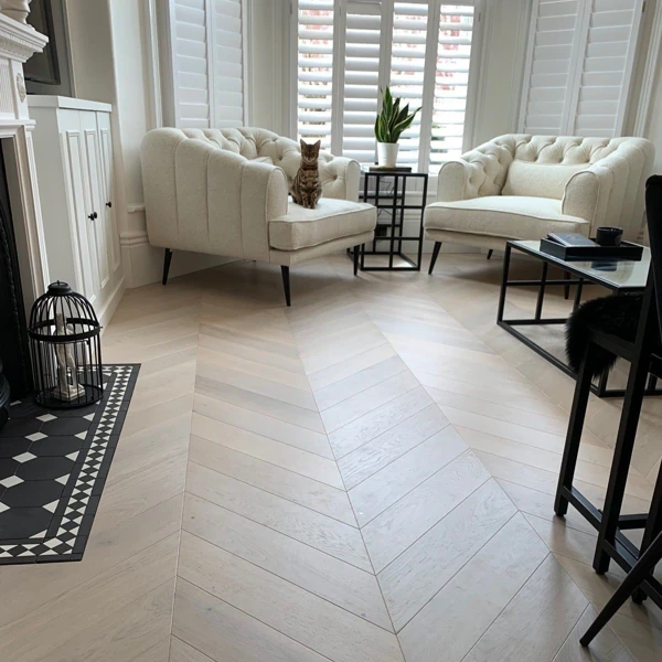 Light oak chevron parquet flooring in a bright modern living room