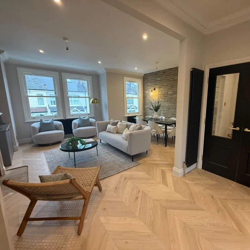 Light wood chevron parquet flooring in an open-plan living room