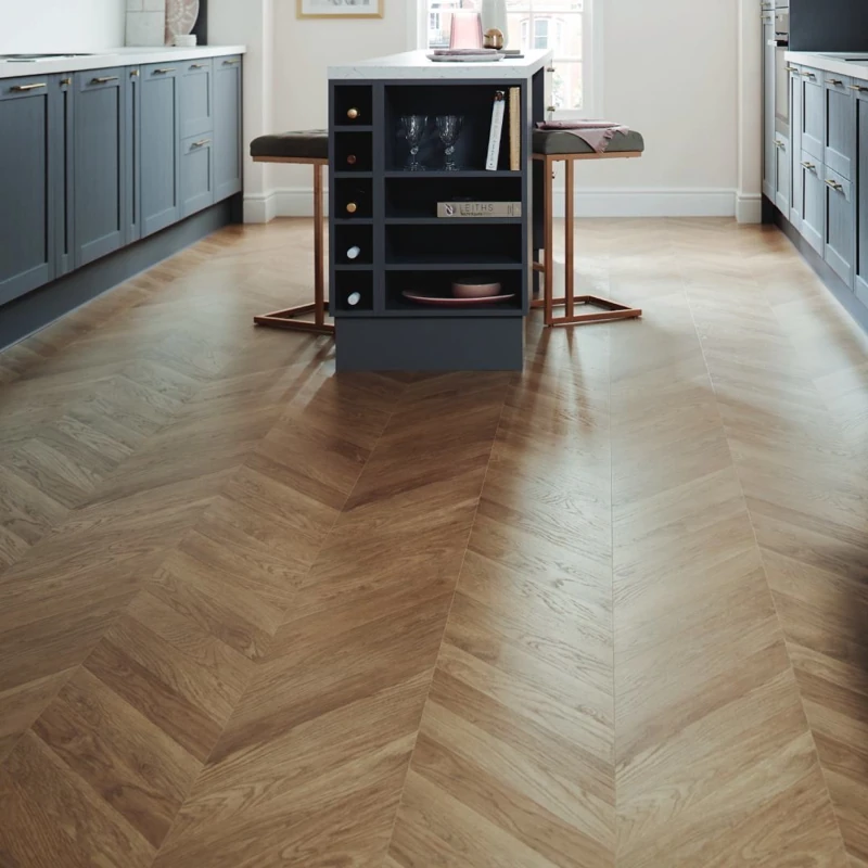 Medium wood chevron parquet flooring in a modern kitchen